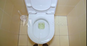 Slow motion shot, peeing, urinating in toilet, first person view. Stream of urine flows into the bowl closeup.
