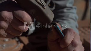 Craftsman hand working with stone. Sculpture with a sculpting tool and hammer carving stone. Stonemason working with his tools. Stone carving. Man using hammer and chisel.