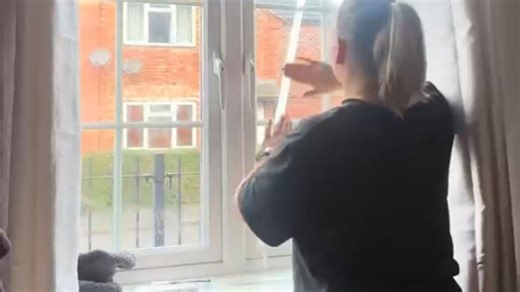 Woman prepares for Christmas season with window painting and seasonal cheer