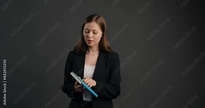 Business woman in suit is browsing through the pages of the diary, young lady searches notes in paper notepad, 4k Prores HQ