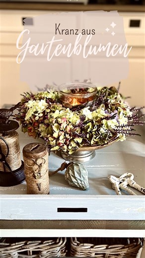 Stephanie Jannette Adele on Instagram: "Kranz aus Gartenblumen Guten Morgen und Prost Kaffee Ich liebe es Kränze zu binden und wie schön ist es wenn man für den Kranz alle Blumen im eigenen Garten findet Zusammen mit einem Windlicht auf einer kleinen Tortenplatte kann der Kranz bis in den Herbst hinein im Wohnzimmer bleiben, obwohl ich bei dem herrlichen Wetter noch gar nicht an den Herbst denken will Bei uns geht erstmal die Schule wieder los, die Kids freuen sich schon riesig, nicht! Ich wünsc