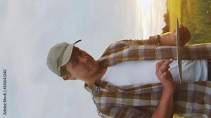Farmer in front of a sunset agricultural landscape. Man in a countryside field. Country life, food production, farming and country lifestyle concept.
