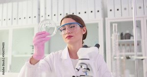 Woman scientist holds Petri dish and observes microbial growth. Experienced researcher inspects sample to detect changes slow motion
