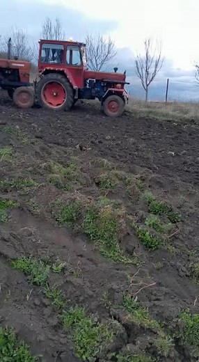 Old Red Tractors Plowing Through Muddy Fields