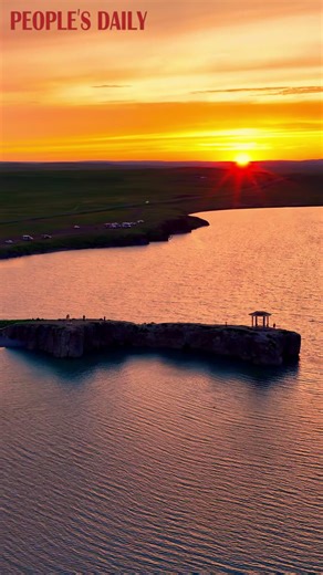 The orange-red sunset glow draped Hulun Lake with a golden, gauzy veil, creating a picture-perfect, dreamlike scene in north China's Inner Mongolia Autonomous Region. | People's Daily, China