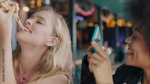 best friends eating pizza at restaurant woman using smartphone taking photo of friend enjoying meal two women having fun sharing weekend together on social media 4k
