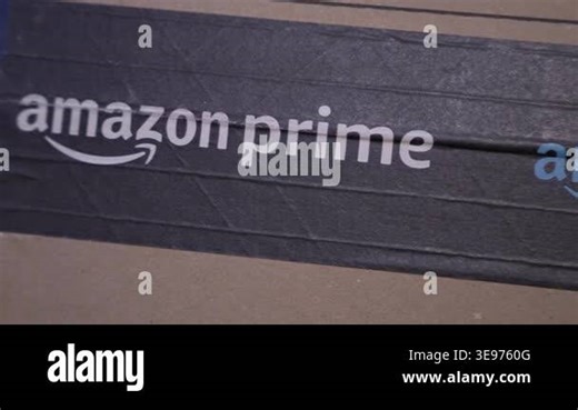 Warsaw, Poland - Dec 10, 2025: Horizontal tracking shot moving along Amazon Prime branded tape on a cardboard shipping box showing printed logo alignment during the camera pass Stock Video Footage - Alamy