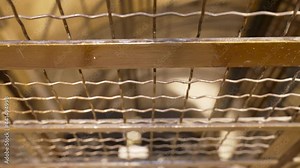 Watching through the metal grid while the ancient elevator descends - close POV shot