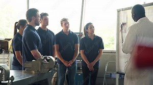 Tutor Discussing Technical Drawings With Apprentice Engineers Stock Video