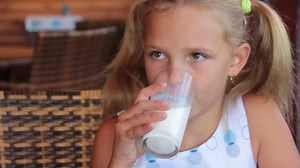 little girl is drinking milk