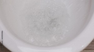 The water is flushed down the toilet, swirls and leaks. The spray flies in different directions