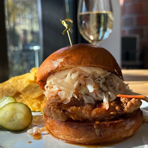 Let us introduce our newest chicken sandwich, "The Honeyed Hen.” This sandwich features fried chicken thighs tossed in midwest hot honey. It’s served on a brioche bun with whole-grain mustard mayo and is topped with house-made pickled cabbage. Warm up your tastebuds with one today! | Farmers Kitchen Bar
