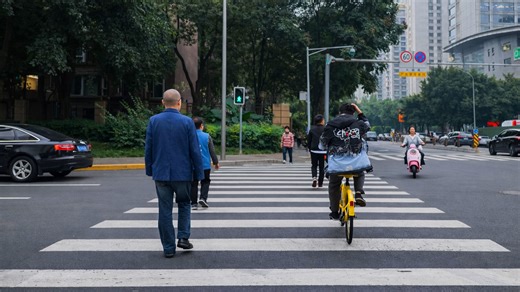 Caminando y pedaleando por un paso de peatones en China