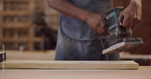 Carpenter, hands and a man sanding wood at workshop for manufacturing process. Closeup of male worker with sander or power tools for creative project, design and production at carpentry factory