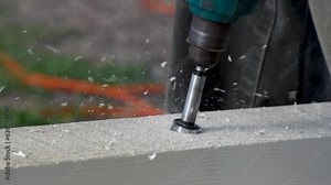 Man drill hole in wood beam close up, forstner drill bit in use