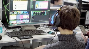 A video engineer working at a computer at a presentation.