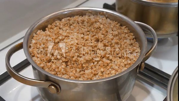 Pot of buckwheat porridge is on gas stove. Boiled buckwheat, kasha