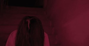 Horror scene of a mysterious Scary Asian ghost woman creepy face with hair covering the face looking to camera with flicker light background dark scene movie at night, holiday Halloween concept