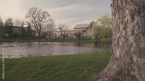 The sun sets over the calm peaceful town of Perth, Ontario as people sit in a park near the Tay River