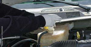 Mechanic or Driver Adding Coolant With Antifreeze Additive To Car or Truck Engine. Routine Maintenance Filling Up The Ethylene Glycol Fluids To Proper Levels.