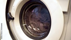 Washing machine running with clothes inside. 4K.