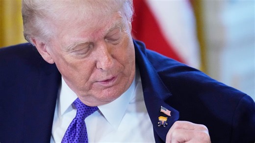 Trump wears a new 'Happy Trump' lapel pin, but insists he's never happy