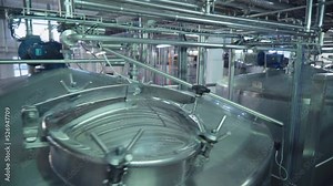 Giant Stainless Steel Containers At A Dairy Production Factory. Stainless Steel Container With Heavy Metal Lid. Stainless Steel Container Used In An Industrial Milk Production Process.