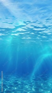 Vertical video, Underwater sunbeams. Underwater sun rays in the Ocean. The sun's rays penetrate underwater into the blue water through the sea waves