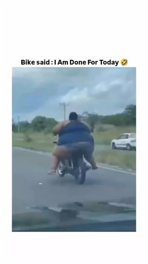 funny videos on Instagram: "This video captures a sudden and dramatic motorcycle accident on a public road, which is being filmed from a vehicle driving behind the bike.​Video Breakdown:​The Scene: Two people are riding a small motorcycle on a paved road with clear lane markings, traveling alongside a grassy median or shoulder. The sky is overcast."