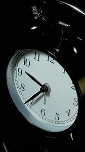Vertical time lapse video of a clock time passing over a day to night.