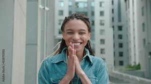 girl with beautiful hair jumping for joy very glad and happy, she showing yes, gratitude gesture. Excellent news. Surprised excited African american happy woman of modern city background