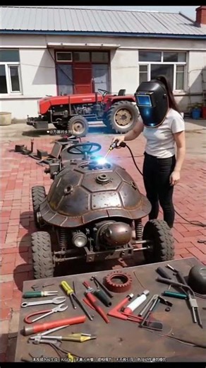 Woman wearing welding helmet modifies turtle-shaped four-wheeled vehicle