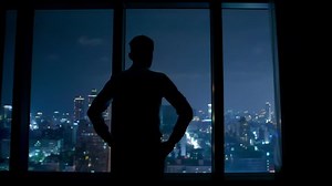 clip-1031954300-silhouette-upset-businessman-watching-through-window-night