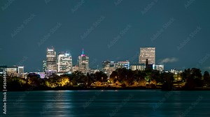 Time lapse of clouds passing over Denver's downtown skyscrapers at night with Sloan Lake prominently in the foreground.