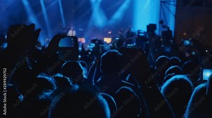 Big crowd at concert cheering clapping hands at night rock concert. Silhouette hands of audience crowd people use smart phones enjoying the concert. 4k, UHD