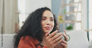 Woman relax on sofa, coffee and watching tv, happy and content, drink and entertainment with remote control. Female at home with smile, hot beverage and break, chilling and online streaming service