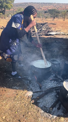 Outdoor Cooking: Woman Prepares Dish Over Open Fire