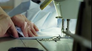 Woman working in a garment factory. Sewing machine close up. You can clearly see how the needle works. Light industry. Tailoring