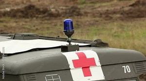 Army Medical Ambulance with blue flashing siren on the battlefield