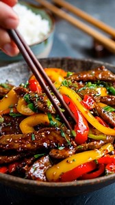 Wok Bœuf Épicé, Poivrons Rouges & Jaunes L'intensité du bœuf saisi et le croquant sucré des poivrons sous une note pimentée Ce wok est un classique de la cuisine minute, où chaque seconde de cuisson compte pour préserver la tendreté du bœuf. Le secret réside dans la découpe très fine de la viande, qui permet une saisie "éclair" à feu vif. Les poivrons rouges et jaunes apportent une douceur naturelle et une texture croquante qui vient équilibrer la puissance de la marinade épicée. C’est un plat v
