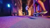 Diversify young men skateboarding ollie back alley at night with...