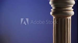 Single ancient greek column rotating slowly on dark blue background, copy space text area
