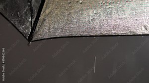 Raindrops on the umbrella raindrops falling. Black umbrella with raindrops slow motion. Drops and splashes. Rainy weather.