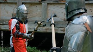 Two militant medieval knights fighting at historical festival. Fantasy, history, reenactment and medieval culture concept