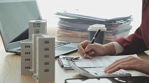 Download Person Hand Doing Property Tax Calculation Using Calculator Of House Model for free