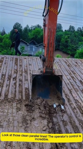 Excavator grading sloped earth, neat striped soil finish