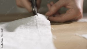 Tailor work: Process of creating from fabric cutting along the tailor chalk markings edge into the bending with an open cut. Hand made garment, towel, tablecloth, clothes, or interior item