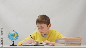Calm schoolboy doing written homework. An excellent student works hard in class. Online learning