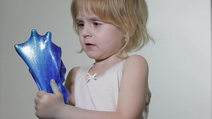 Child having fun making slime. Kid playing with hand made toy slime.