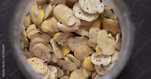 Grain weevil bugs in jar with dry beans, common domestic pest on stored grain food, close-up